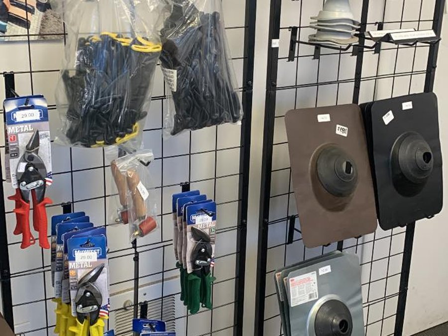 The Caliber retail rack — bagged screws, metal snips, gloves, and color-matched fastener accessories